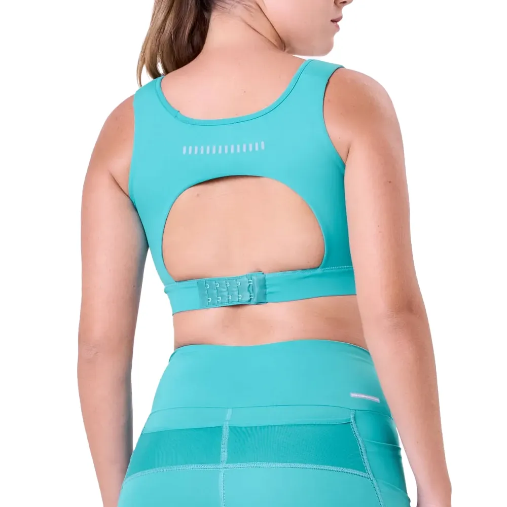 Mulher de costas usando top esportivo azul claro Authen com design ventilado e logo GRIT